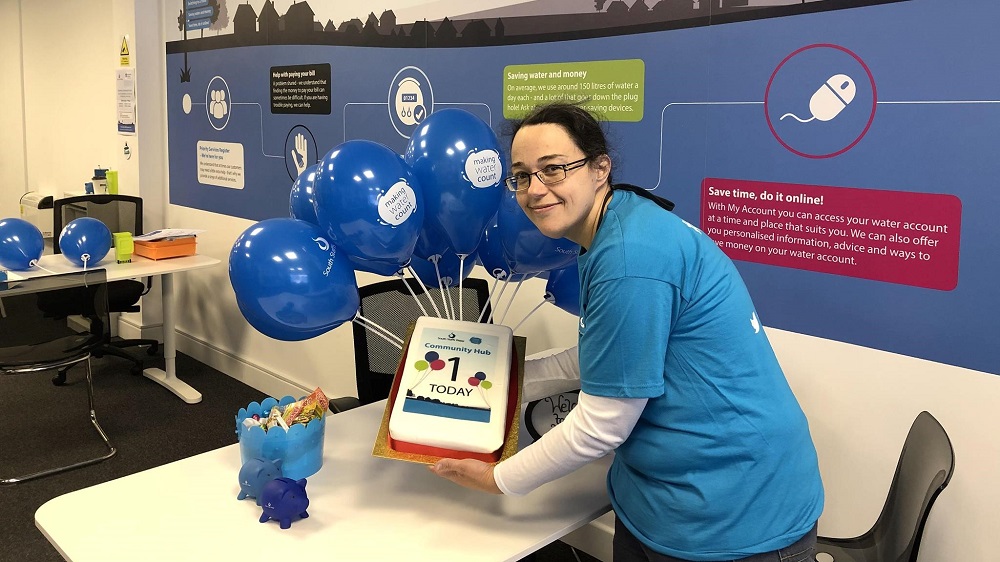 Photo shows hub advisor, Becky, with an anniversary cake.