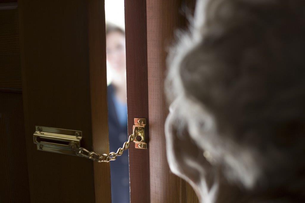 Photo of a lady with a safety chain on her front door