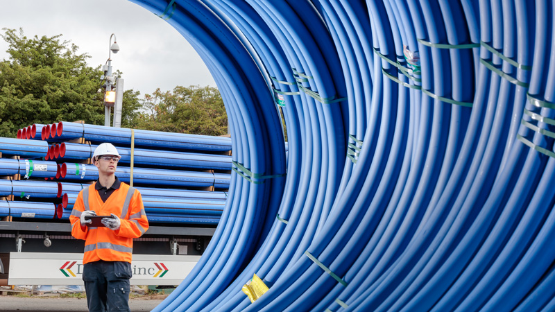 Worker by cable-tied pipework